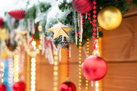 Festively decorated facade of the building of the house, on the street in winter, on a blurred background. Christmas lantern, balls, branches, lights. New Year holidays, background, winter season.の写真素材