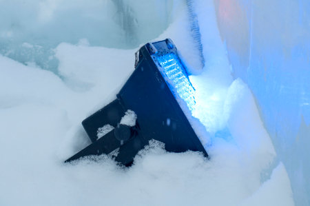 Spotlight light in the snow on the street, winter. Outdoor holiday lighting, in harsh cold weather conditions. Landscape LED lighting in winter. Concept - reliable operation under snow and ice.の写真素材