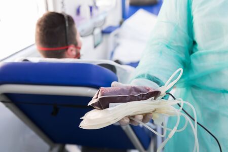 Doctor holding fresh donor blood for transfusion. Donation blood to support during a pandemia of coronavirusの写真素材