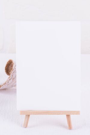 Simple festive, wedding, birthday or business table setting and mock up invitation on white background. Blank card mockup. Minimal home decor. Simple modern interior designの写真素材