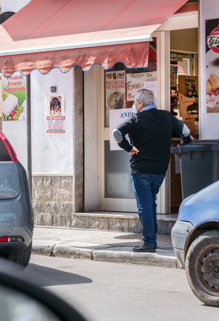 Avetrana, Italy, - Marth 21, 2020. A man in medical masks waiting for enter the store. Comply with safety regulations during epidemy of coronavirus, Shopping during pandemia of Covid-19のeditorial素材