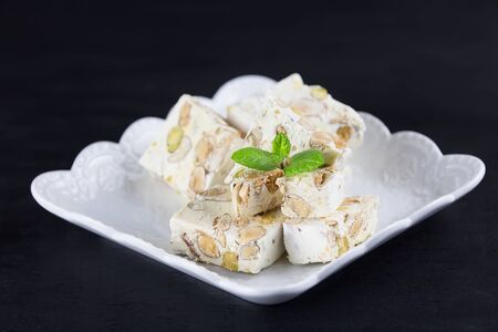 Italian torrone or nougat with almonds and pistachios from Apulia, traditional christmas sweets. Copy spaceの写真素材