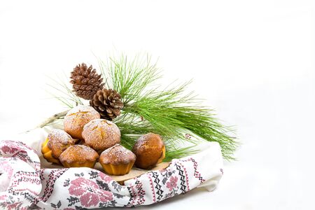Homemade cristmas cupcake, christmas muffins and new yaer decoration on the light background and pine branches and cones, copy spaceの写真素材