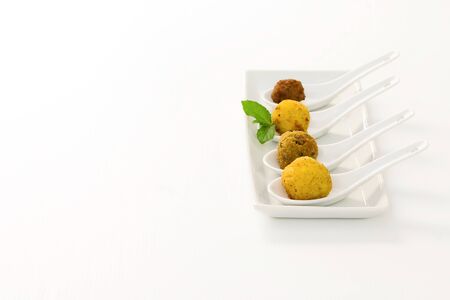 Fried meat balls with sauce in a white plate on white background