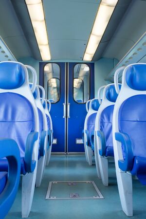 Empty interior of the train for long and short distance in Europe, Italy, train carriage with blue seats, vertical orientation