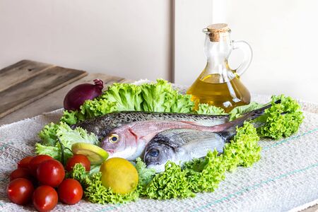 fresh see bass and other fish with some ingredientsの写真素材