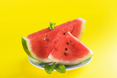 Slices of watermelon on yellow background. Summer concept, close up, space for text. Healthy Summer Snack Concept, copy spaceの写真素材