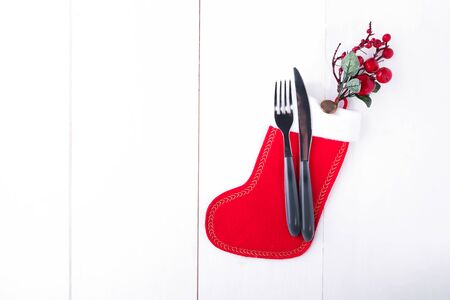 Table setting for celebration Christmas and New Year Holidays on white wooden table. Festive place setting for christmas dinner with red christmas stocking and natural decorations. Top viewの写真素材