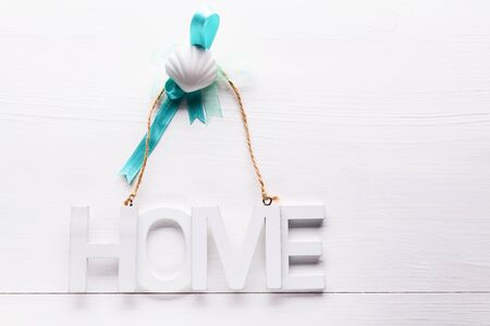 Nordic style still life on a white wooden background with wooden letters with the inscription Home, the concept of home or home purchase close up and copy spaceの写真素材