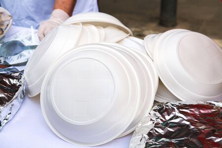 A pile of plastic plates on the street. Ban disposable plastic utensils. Ecology concept. Close-upの写真素材