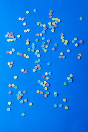Festive blue background: colored sweet confetti, space for your text, top viewの写真素材