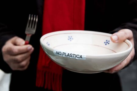 No Plastic plate, the hands of an elderly italian activist hold a plate with the inscription no...
