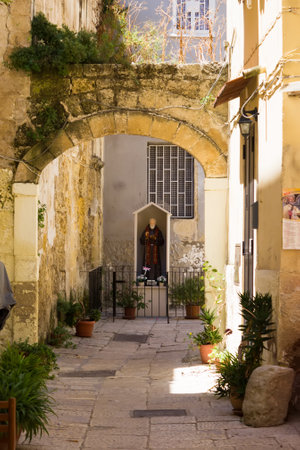 BARI, ITALY - JULY 11, 2018, View of a narrow street in Bari, one statua of San Nicola hangs on the street at home in the center of Bari, Apuliaのeditorial素材