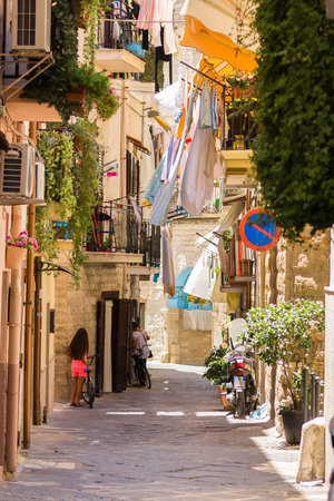 BARI, ITALY - JULY 11, 2018, View of a narrow street in the Italian city Bari, linen is dried in the streetのeditorial素材