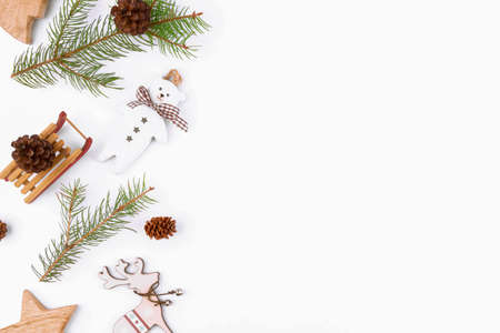 Christmas background of fir twigs, wooden zero waste home decoration: sleigh, cone, reindeer, stars...