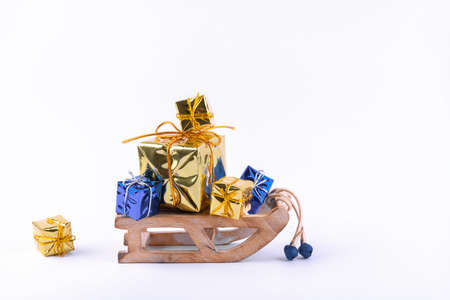 A wooden zero waste small toy sleigh with gold and blue gifts, New year is coming. Reusable sustainable recycled decor. Eco friendly new year. Flat lay Merry Christmas carの写真素材