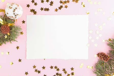 Christmas card mockup template with fir twigs and golden stars and festive decoration on a pink pastel background. Design element for CHristmas and New Year congratulationの写真素材