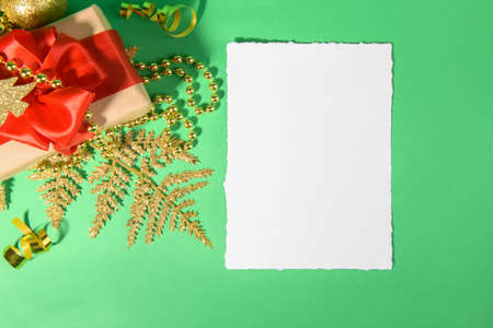 Christmas card mockup template with gift golden festive decoration on a green background. Design...