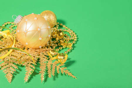 Christmas golden ball with golden Christmas decoration on a green paper, Christmas and New Year background for web bannerの写真素材