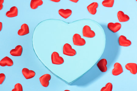 Blue heart shape gift box with red hearts on a blue backround, Celebration Valentine's day, holiday,...