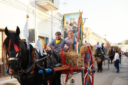 AVETRANA, ITALY - JUNE, 13, 2019. parade of horses with carriages decorated with wheat and flowers in honor of the celebrations of Saint Anthony of Padua, the religious procession walks on the streetsのeditorial素材