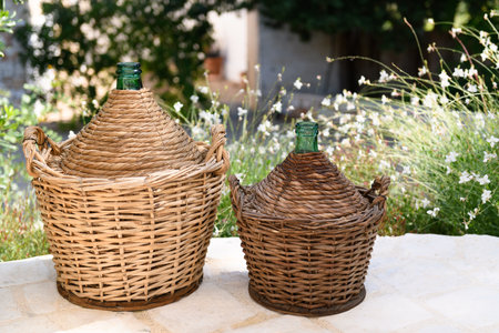 Due demijohn in a garden, made in Puglia