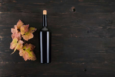 Top view of bottle of red wine fall grapes leaves a on dark wooden background, concept of traditional red wine flat lay background, copy spaceの写真素材