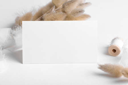 Wedding stationery folded blank card mockup 3.5x2 on white table background with boho decor, feminine blog or wedding invitation rvsp. Minimal bohemian style mockup, thank you card or greeting cardの写真素材