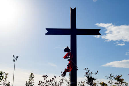 Silhouette of Jesus Christ cross on a blue sky background with clouds and sunbeams. Easter, resurrection concept. Christian cross of God at the field on the rays of the sun outdoor. religion backgroundの写真素材