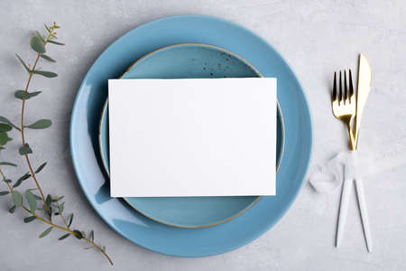 Wedding stationery invitation card mockup 7x5 on gray background with eucalyptus, Menu card mockup with festive wedding or birthday table setting, blue ceramic plate. Minimal blank card mockupの写真素材