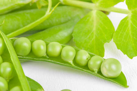 Fresh organic raw green opened peas pod on white background. Healthy eating, vegan and vegetarian legume food, raw food and detox super food, bean protein, close upの写真素材