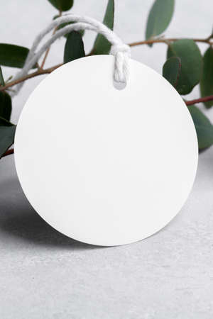 Round white gift tag mockup with eucalyptus leaves on gray background, label tag mockup, Wedding...