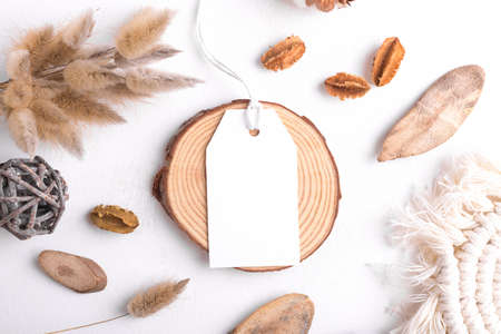 Rectangle white tag mockup on a white background with cotton string and boho decoration, dry plants, element for packing. Label product bohemian mockup copy space for text and natural eco designの写真素材