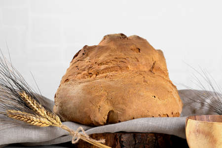 The bread of Matera, Pane di Matera on linen napkin on white wooden background, typical southen italian sourdough breadの写真素材