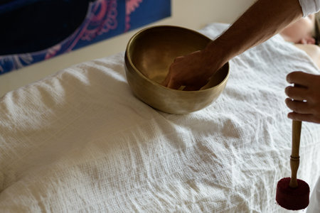 Male hands with Nepal Buddha singing bowl, close up, master of healing sound massage, doing sound therapy with tibetan singing bowl, alternative medicine, mental healthの写真素材