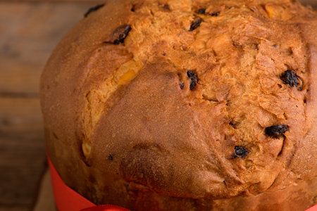 Traditional Italian Christmas Cake Panettone with on wooden rustic background. Homemade artisan sourdough panettone ready for eating. Classic italian Christmas Food and Edible gift, close upの写真素材