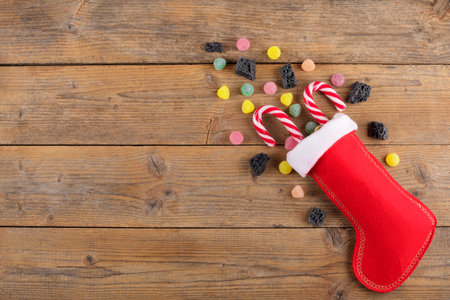 Red Epiphany Befanas stocking with sweet coal and candy on rustic wooden background, Italian...