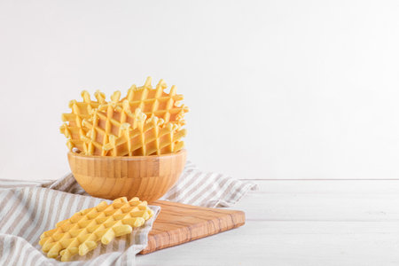 Ferratelle or pizzelle a traditional dessert or cookies from Abruzzo in a bowl on white wooden background, copy spaceの写真素材