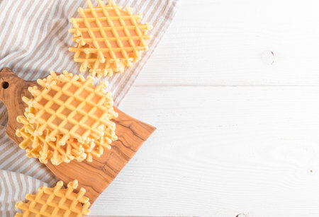 Ferratelle or pizzelle a traditional dessert or cookies from Abruzzo on a cutting board on a white wooden backgroundの写真素材