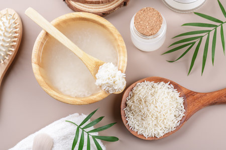 Homemade cosmetic rice water with ingredients on beige background, healthy beauty treatment ingredients for homemade comsetics, beauty recipe for home spa, natural skincare preparation, top viewの写真素材
