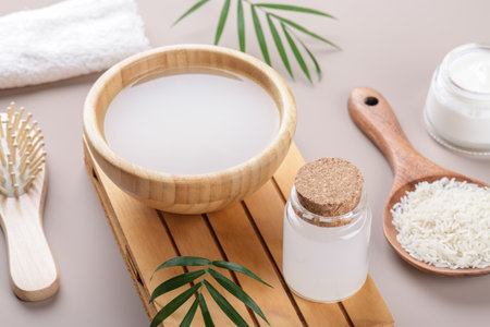 Homemade cosmetic rice water with ingredients and beauty kit on beige background, healthy beauty treatment ingredients for homemade comsetics, beauty recipe for home spa, natural skincare preparationの写真素材