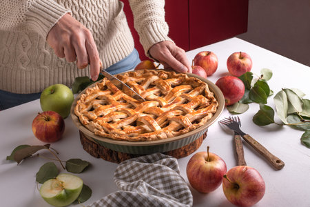 Woman cutting a baked apple with a khife, Thanksgiving traditional dessert ready to eatの写真素材