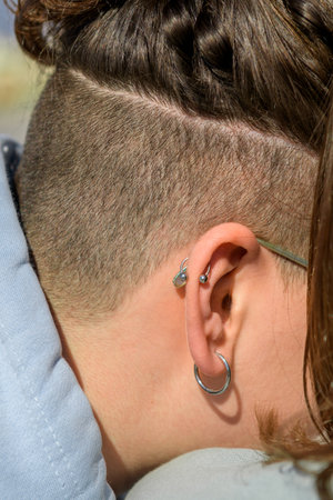 Head with teenage hairstyle, ear close-up with earringの写真素材