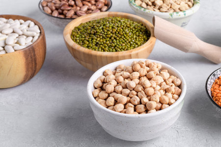 Dry chickpeas and mung beans in a bowl on gray table background. Mixed pulses for healthy and balanced diet, plant-based protein sourcesの写真素材
