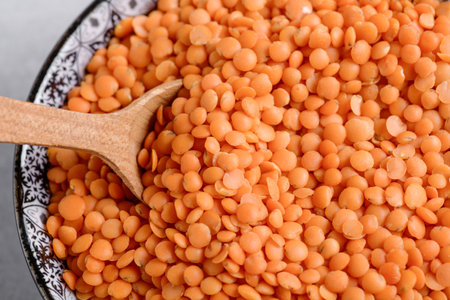 Red lentil texture with wooden spoon, close upの写真素材