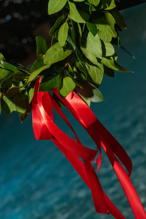 laurel wreath made of fresh leaves is adorned with red ribbon as graduation symbolの写真素材