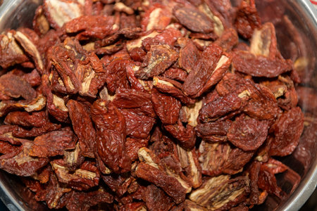 Sun-dried tomatoes fill a large metal bowlの写真素材