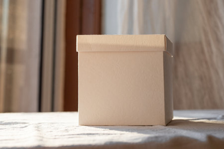 Sunlit White Box Mockup on a Table Near a Window During Sunset Hoursの写真素材