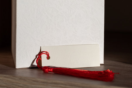Blank card mockup with Red Tassel Displayed on Wooden Shelfの写真素材