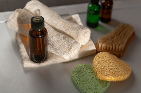 Cosmetic dropper bottles with sponges and other tool for beauty routine on sun rays in bathroom, view from above. Beauty care for face and body careの写真素材